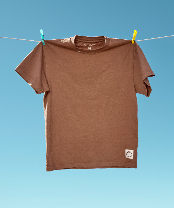 Original Tee (Brown) hanging from a clothesline against a clear blue sky