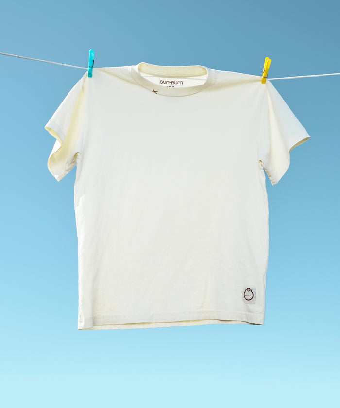 Original Tee (Cream) hanging from a clothesline against a bright blue sky